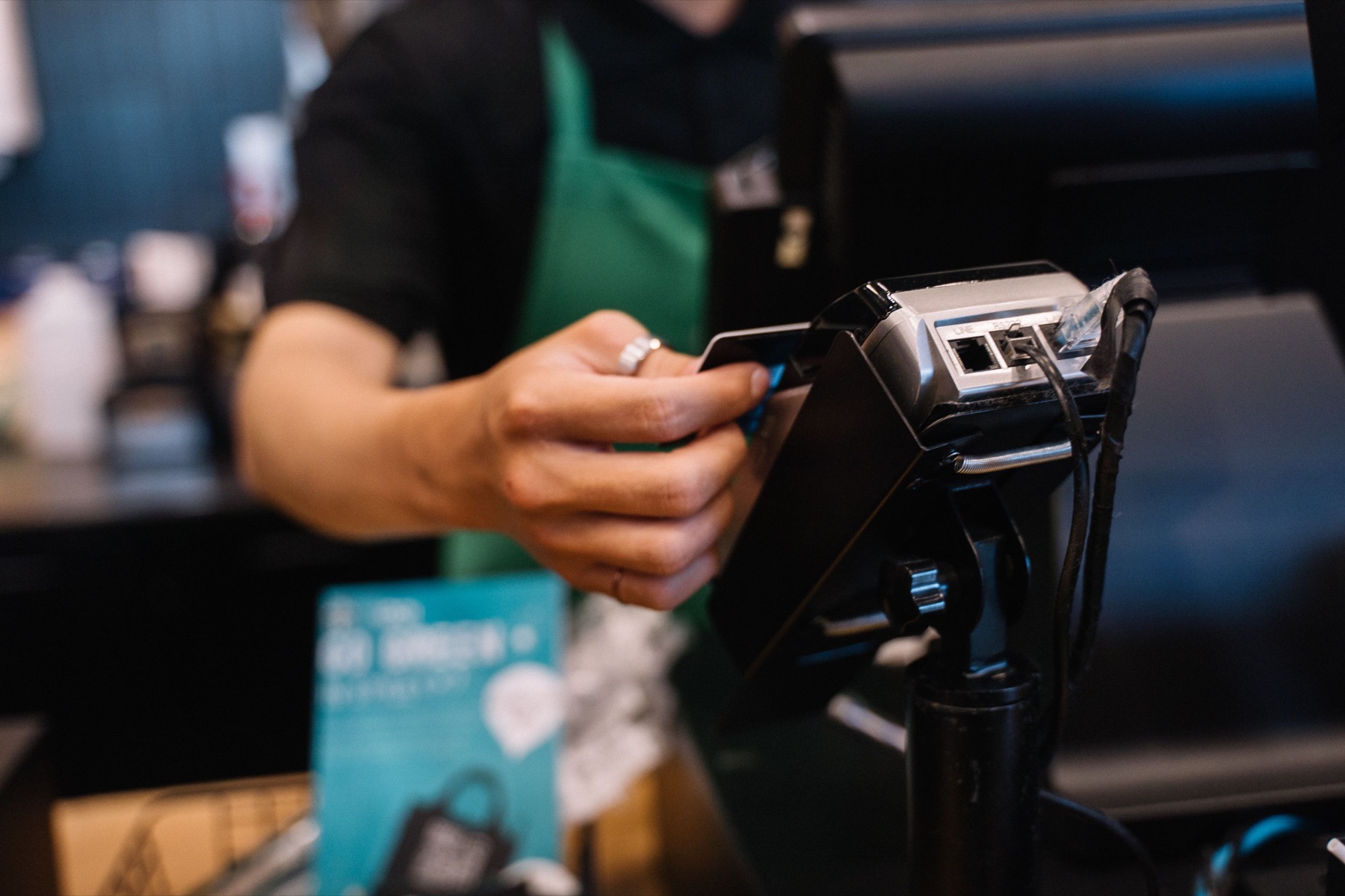 A merchant accepting a contactless card payment at the counter
